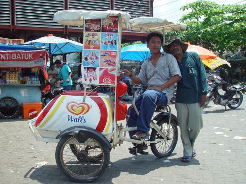 A bicycle-based ice cream vendor in Indonesia - Ice cream can be mass-produced and thus is widely available in developed parts of the world. Ice cream can be purchased in large cartons (vats and squrounds) from supermarkets and grocery stores, in smaller quantities from ice cream shops, convenience stores, and milk bars, and in individual servings from small carts or vans at public events. In Turkey and Australia, ice cream is sometimes sold to beach-goers from small powerboats equipped with chest freezers. Some ice cream distributors sell ice cream products from traveling refrigerated vans or carts (commonly referred to in the US as 'ice cream trucks'), sometimes equipped with speakers playing children's music. Traditionally, ice cream vans in the United Kingdom make a music box noise rather than actual music.