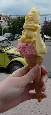 Philippine Sorbetes (Filipino Ice Cream) - Sorbetes is a Filipino version of ice cream usually peddled from street carts in the Philippines. It is distinct from the similarly-named sorbet. It is also commonly called 'dirty ice cream' because it is sold along the streets exposing it to pollution and because the factory where it comes from is usually unknown. It is usually served with small wafer or sugar cones and recently, bread buns. Ice cream was introduced in the Philippines during the time of the American invasion when refrigerators and other cooling devices were introduced. While American ice cream was made with cow's milk, using the milk of the carabao, a kind of water buffalo, resulted in a cheaper product which became known as'sorbetes.' Both kinds of milk are widely used today. Flavors also varied from the usual natural fruits such as mango, avocado, coconut to flavors imitating commercial ice cream such as chocolate, cookies and cream, cheese, mocha, etc. The sorbetes industry competes with commercially available ice cream from giant companies operating in the Philippines such as Magnolia and Selecta, which also started peddling their product in the streets in more sanitized carts. Sorbetes is peddled by sorbeteros using colorfully painted wooden carts which usually can accommodate three flavors, each in a large metal canister. Peddlers get their carts from makers scattered around the cities of the Philippines in the morning and walk the streets the whole day, calling consumers from their houses by ringing a small handheld bell. The wooden cart has two large wooden wheels at the front part to easily push the cart though latest carts are already attached to bicycles. The cart is stuffed with shaved ice sprinkled with salt to produce a lower temperature around the metal canisters and keep the sorbetes frozen longer. The whole sorbetes cart is also available for private gatherings when negotiated with the sorbetero. It is usually cheaper that buying gallons of ice cream to be served to guests. Peddlers of sorbetes provide several serving options. It may be served in a small plastic cup, a wafer cone, a sugar cone or a bread bun, at varying prices. A serving can include one flavor or, for no extra charge, a mixture of available flavors. Sorbetes is usually consumed as a snack while travelling. It can also be served as dessert.