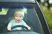 Baby - portrait of baby sitting behind steering wheel of car