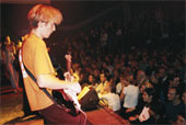 concert - Young man playing electric guitar in musical concert