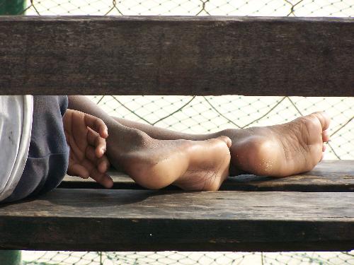 on his feet - homeless boy sleeping on the benches near our local tennis court. photo: luntian