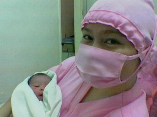 delivery room nurse with the newborn - this is a picture of a delivery room nurse after doing the initial newborn care.
