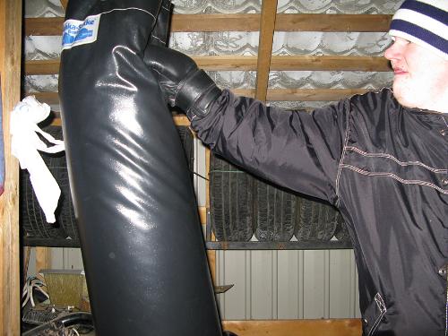 Hitting 100 lbs (45 kg) heavy bag - Shoulder Whirl right hand hitting the heavy bag and denting, lifting it up and twisting in the progress. Shot in Finnish winter in storage house, without no heating...