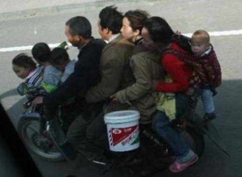 Family of 8 on a Motorcycle - The photo shows a family of 8 on a motorcycle, traveling from one place to another.