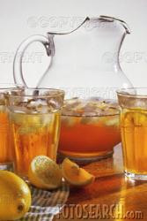 Ice Tea - A glass pitcher of ice tea with glasses of ice tea. 