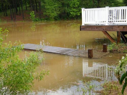 Too Much Rain!!! - Would anybody like some of this? Our pier is normally 12 to 15 inches above the water level. This is what we got in one day! There are flood drains that go underneath the road to the other side which is lower and it's either a small trickle of water on that side or nothing at all. This day, it was a raging river! The flood drains couldn't keep up with all the rain.