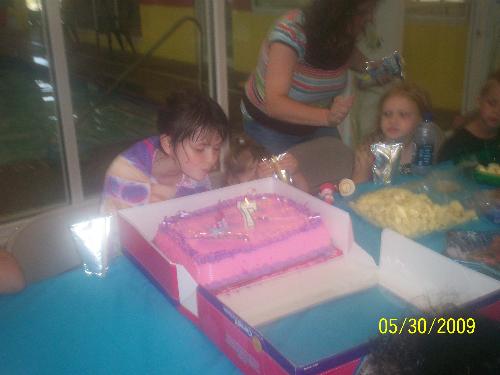 Lizzy blowing out candles - My granddaughter, Lizzy is blowing out candles on her birthday cake. It was an ice cream cake and the decorations on it was Hannah Montana.
