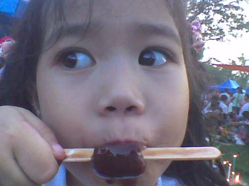 enjoying the popsicle - Ella is eating her twin popsies