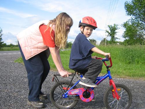 Teaching Wesley to Ride - My daughter giving her younger brother a helping hand.