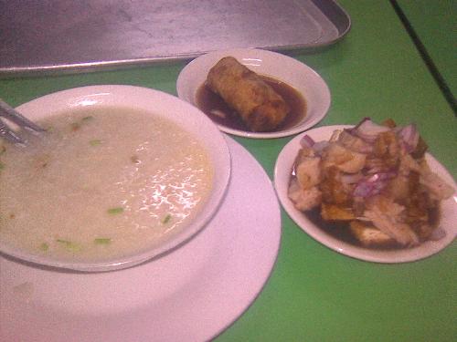 A filipino snack - rice porridge, combined tofu and pork, and fried lumpia