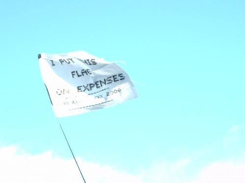 I put my flag on expenses.... - One of the flags the audience is holding while listening to music at Glastonbury Festival.