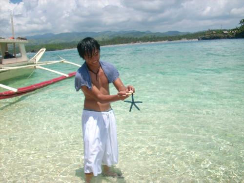 blue starfish in Boracay - A Boracay tourist holding a blue starfish