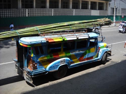 jeepney - This is a jeepney in my city preparing to unload some bamboos. It's the local transportation here aside from the tricycle. Some have different designs on its side, the one on the photo is just a simple one. A jeepney can accommodate 24 persons but can have more than this since some drivers let thers take the top part.