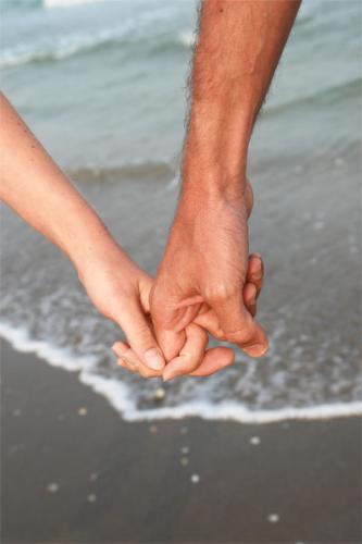 holding hands - a yong man and woman holding hands