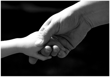 reaching out - an adult holding the hand of a child