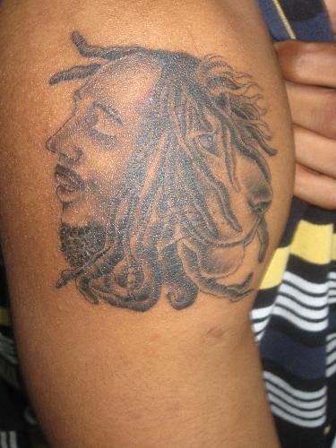 what the best looking tatoo you can find? - this is my brother's tatoo of the late reggae singer bob marley and a lion. he is a great legend in my country jamaica. Many people love his music because he was like a martin luther king jr but through his singing