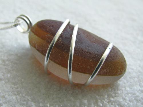 Caramel and Coffee Sea Glass Necklace - The colors in this brown multi colored piece of sea glass remind me of coffee and caramels. The beautifully round and smooth shard of English 'end of day' glass measures 1' L. It is wrapped with sterling silver wire and dangles from an 18' sterling silver Venetian box-style chain.  A beautiful end of summer/autumn accessory! Hold it up to the light and admire the earthy wood-grain tones....simply one of the most unique pieces of sea glass I have ever worked with!