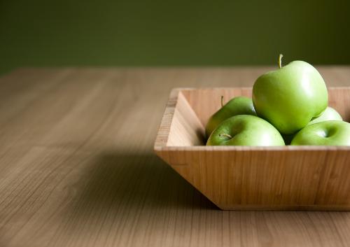 Life needs to be a bit simple - some green apples,a table and a plate are made of woods.That is it.