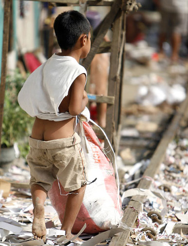 Working with the garbages - Garbage... something that is ready for disposal. No use at all. But for many poor families the garbage has been their steady source of income. In many places I see not just adults but even kids like in this picture who works for a living in a dumpsite. Kids as young as those who can manage to walk and carry some item can come... it is a difficult and health hazardous situation but its better that to die of hunger.