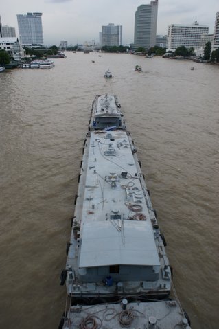 Floating on the River Chaophraya - This is a shot of a carrier / container in the Chaophraya river of Bangkok. 3-4 or more container boats are tied together and pulled along the river by a mini boat ! They contain sand or similar material to be transported from the port or along the riverside....
