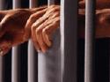 Jail - Man in jail with hands hanging out Jail - Man in jail with hands hanging out