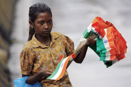 A girl selling Indian flag - A patriotic poor girl selling national flag to fill her stomach. This is the most awkward situation of India