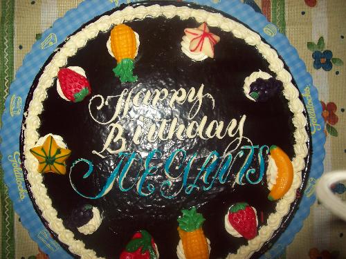 choco cake - chocolate birthday cake with choco frosting and fruits made of icing surrounding the cake.
