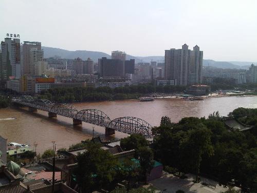 Lanzhou of China - this is the full view of Lanzhou. the yellow water is the famous of Yellow River. the bridge in the photo is the'Zhongshan Bridge'