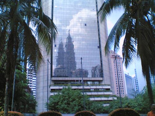 Petronas Twin Towers (Its Reflection) - A reflection of Petronas Twin Towers (the 3rd highest towers in the world) on a nother glass building, accompanied by two beautiful palm trees!