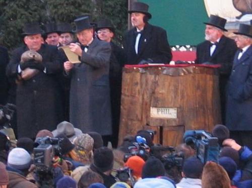 Groundhog Day - Punxutawney Phil is being held by the man on the left. His 'house' is this tree stump, well fake tree stump. Groundhog Day is February 2nd, each year.