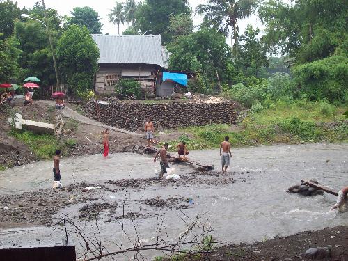 building a foot bridge - community residents help build a foot bridge in the middle of a storm so others can cross the river. Located at one of the sites of habitat for humanity in Central Philippines