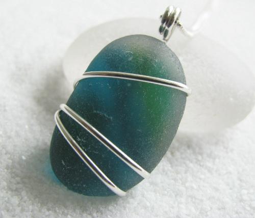 Blue-Green English Sea Glass Necklace - This gorgeous, chunky piece of English sea glass is layered with deep aqua blue & and green glass, within a clear glass gem. The striking gem measures 1' in length, is wrapped in sterling silver wire, and hangs on an 18' Venetian box-style sterling silver chain.
