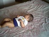Baby Lying In Bed - The baby is lying in his bed.