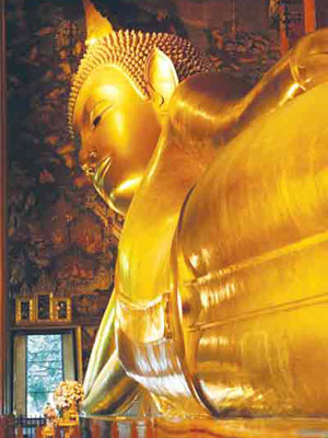 Budha -  Thailand’s largest Reclining Buddha dwarfs an open door. It is so large (46m long and 15m high) that it is a tight squeeze to fit in the temple that houses it, allowing mostly only partial views of its face and body, at Wat Pho Temple, in Bangkok.