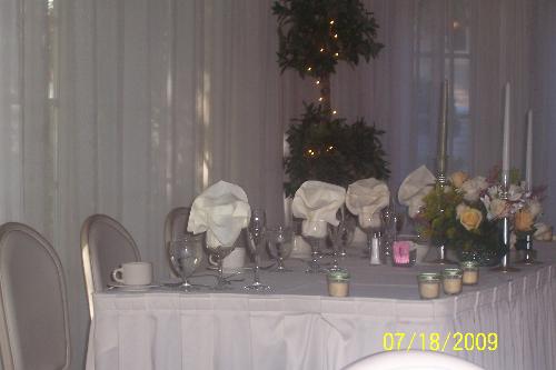 Bride and Groom Wedding Party Table  - Table set up for the party of the Bride and Groom decorated in sage and white decorations at the reception banquet.