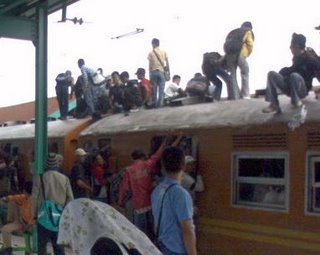 On the roof of the train - This is an everyday view of the train station in indonesia when the policy to catch people whose sit on the roof not yet implemented. Many people sit on the roof of thet rain.