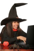 Girl dressed in Witch Costume - Girl on computer dressed in witch costume for halloween