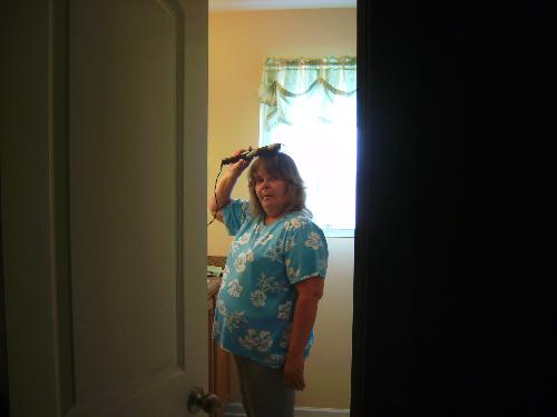 Hair - Lady curling her hair getting ready to go out