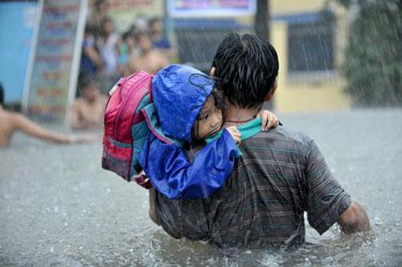 Typhoon Ondoy Aftermath - a man and a young child tries to wade their way through a very flooded street