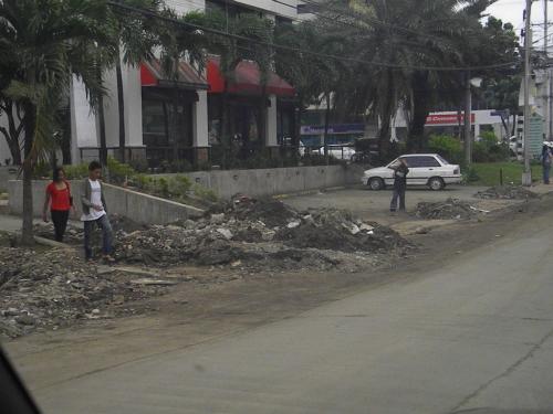 after the deluge - a street that resulted from the tropical storm Ondoy. Huge piles of muds, debris, and even trash are seen. Roads were destroyed, lives lost, families and homes washed away.