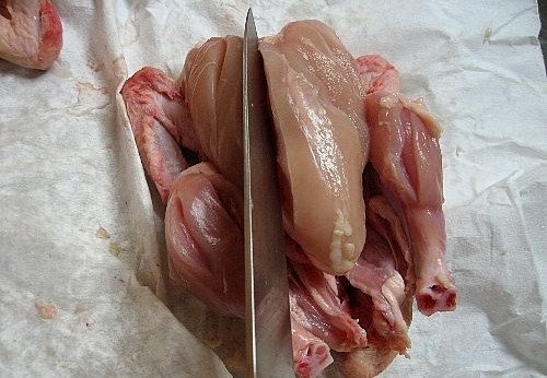 Chicken - Chicken being given small cuts to make it ready for tandoor