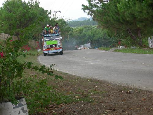 jeepney - local travel is by a jeepney with passengers on the roof in one of the upland communities in central philippines.