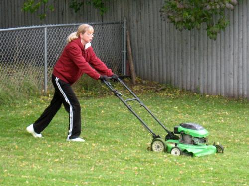 Busy Woman - My wife,mowing the back yard.