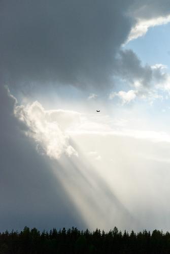 Sun rays splitting dark clouds - It was a beautiful day with some dark cloud layers pulling across the sky, then suddenly the sun teared through the thick layer of clouds and I lost my breath for a moment, admiring the heavenly composition of light and darkness. Unfortunately, I am just not that good at capturing such grand moments with a camera, but I tried.