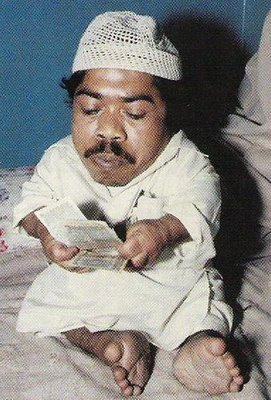 Shortest man - This is the picture of the shortest man in subcontinent.In this picture he is counting cash.