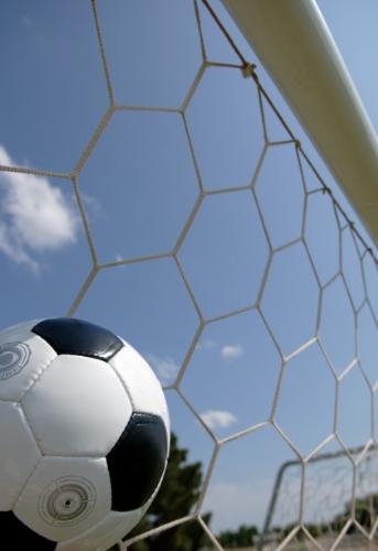 Football - Football in a goal net.