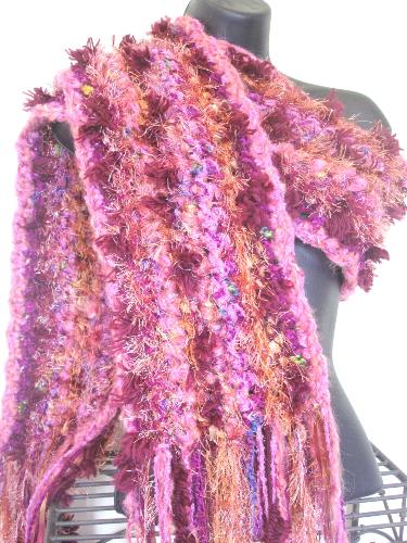 California Sunset Scarf - The California Sunset scarf is hand crocheted with a mixture of yarns in shades of copper, pink, mauve, and plum. Yarn fibers include: super-soft brushed acrylic, metallic, eyelash, and chenille. Makes for a unique combination & a glamorous accessory.