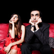 Cinema - Bored couple sitting in a cinema theatre and watching a movie uninterestingly. Hope life exist happy only when there is understanding between the lifepartners. Otherwise it goes bad and bore even if have all the good things with us.