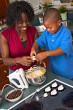 Cracking eggs - This is the photo of a mother and a kid cracking eggs in the kitchen