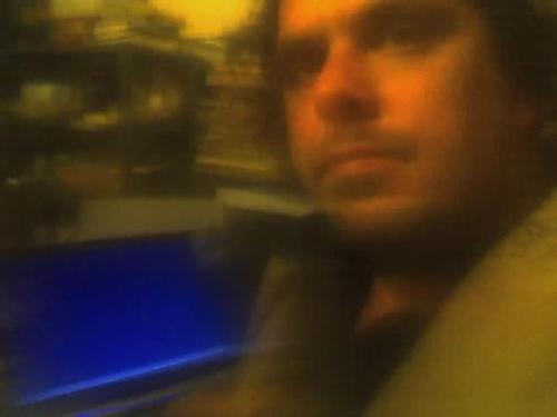 My morning starts at Midnight... - Snapping a photo of myself at my work from home station, laptop glowing blue. The cellphone took a much better headshot than I had expected, it is the one I use for my resume today still.